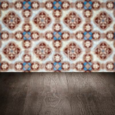 Wood table top and blur vintage ceramic tile pattern wall