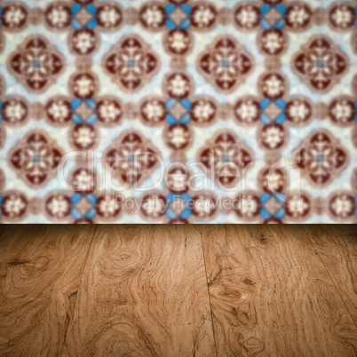 Wood table top and blur vintage ceramic tile pattern wall