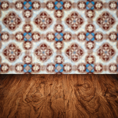 Wood table top and blur vintage ceramic tile pattern wall