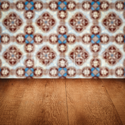 Wood table top and blur vintage ceramic tile pattern wall