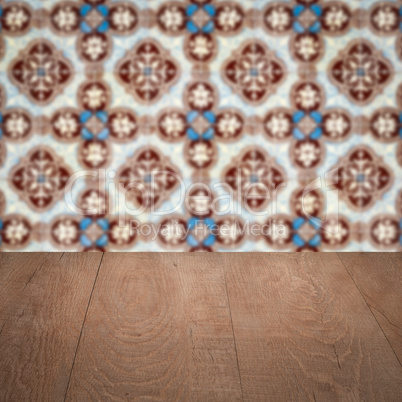 Wood table top and blur vintage ceramic tile pattern wall