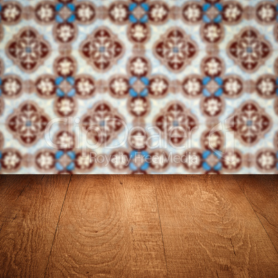 Wood table top and blur vintage ceramic tile pattern wall