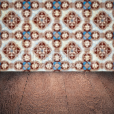 Wood table top and blur vintage ceramic tile pattern wall