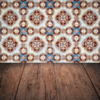 Wood table top and blur vintage ceramic tile pattern wall