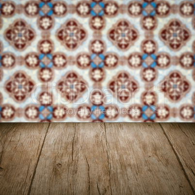 Wood table top and blur vintage ceramic tile pattern wall