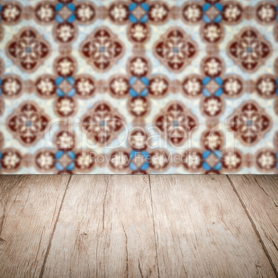 Wood table top and blur vintage ceramic tile pattern wall