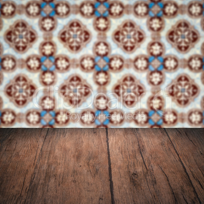 Wood table top and blur vintage ceramic tile pattern wall