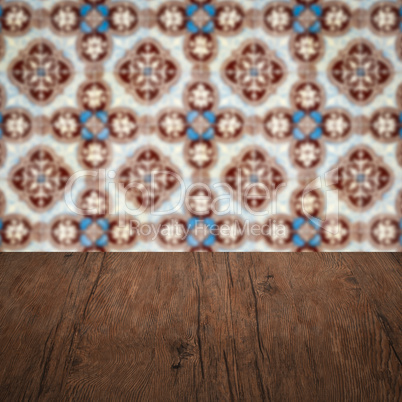 Wood table top and blur vintage ceramic tile pattern wall