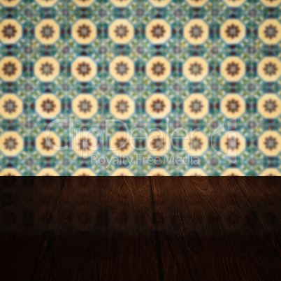 Wood table top and blur vintage ceramic tile pattern wall