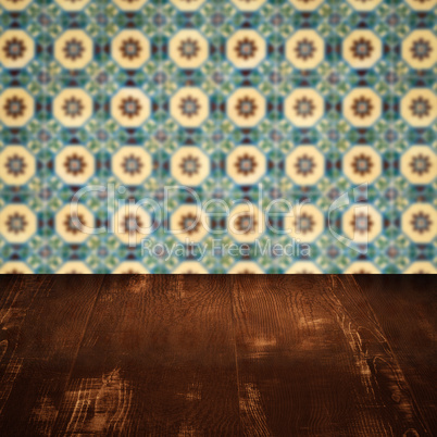 Wood table top and blur vintage ceramic tile pattern wall