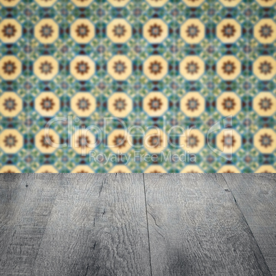 Wood table top and blur vintage ceramic tile pattern wall