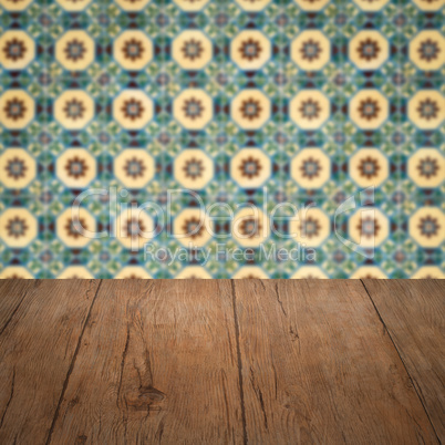 Wood table top and blur vintage ceramic tile pattern wall