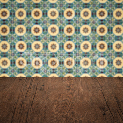 Wood table top and blur vintage ceramic tile pattern wall