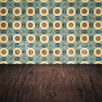 Wood table top and blur vintage ceramic tile pattern wall Wood table top and blur vintage ceramic tile pattern wall