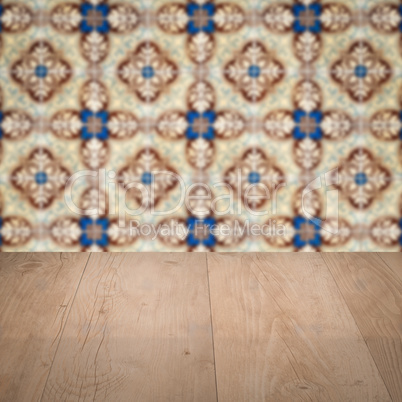 Wood table top and blur vintage ceramic tile pattern wall