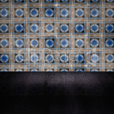 Wood table top and blur vintage ceramic tile pattern wall