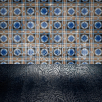 Wood table top and blur vintage ceramic tile pattern wall