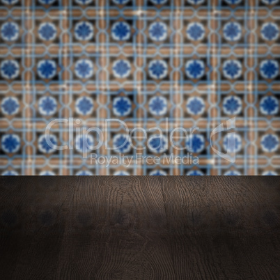 Wood table top and blur vintage ceramic tile pattern wall Wood table top and blur vintage ceramic tile pattern wall