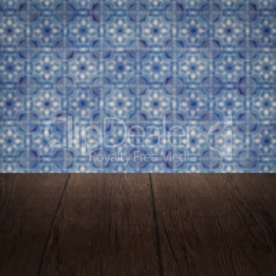 Wood table top and blur vintage ceramic tile pattern wall