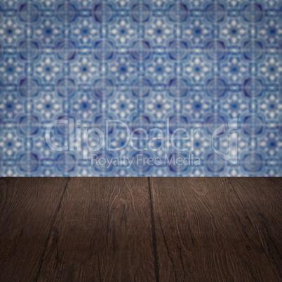 Wood table top and blur vintage ceramic tile pattern wall