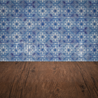 Wood table top and blur vintage ceramic tile pattern wall