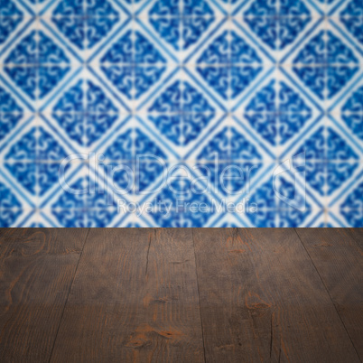 Wood table top and blur vintage ceramic tile pattern wall