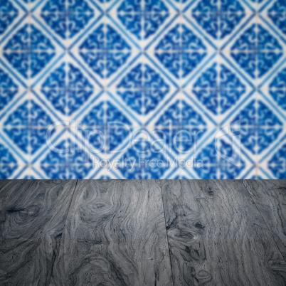 Wood table top and blur vintage ceramic tile pattern wall