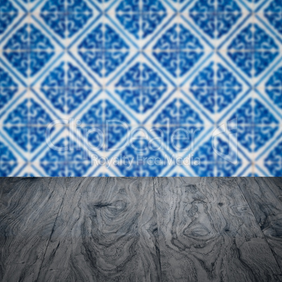 Wood table top and blur vintage ceramic tile pattern wall