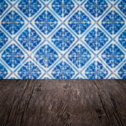 Wood table top and blur vintage ceramic tile pattern wall