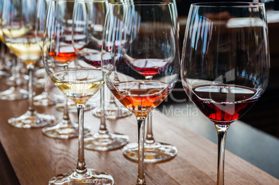 Three wine glasses with samples on wood counter