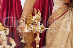 Woman lighting up the metal oil lamp