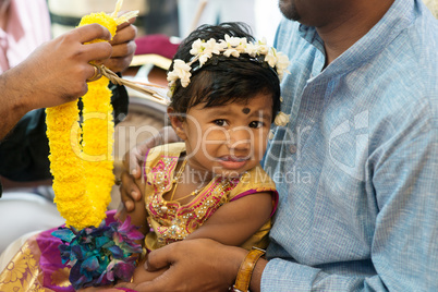 Baby girl received flower garland from priest.