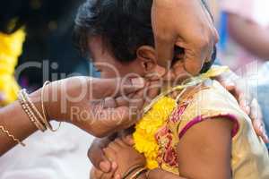 Baby girl in ear piercing ceremony