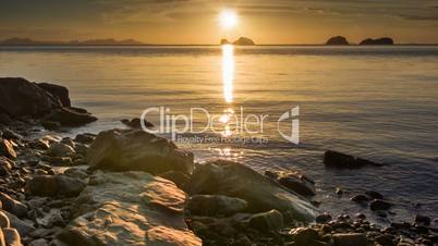 Calm sea at sunset rocks beach