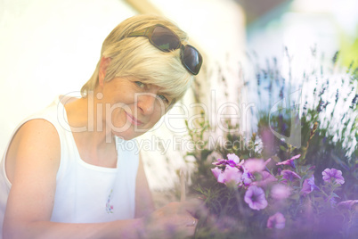 Seniorin pflegt ihre Balkonblumen