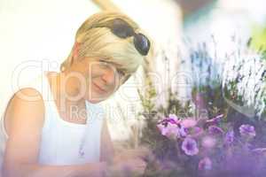 Seniorin pflegt ihre Balkonblumen