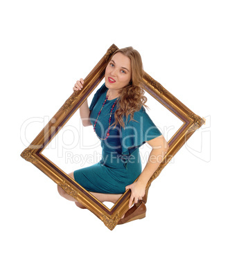 Woman looking trough picture frame.