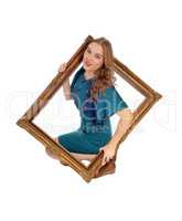 Woman looking trough picture frame.