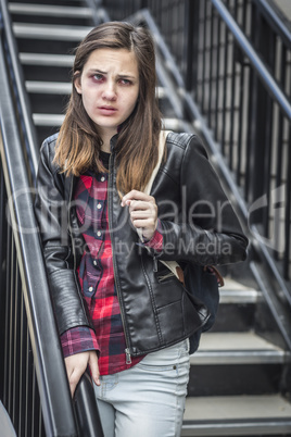 Young Bruised and Frightened Girl With Backpack on Staircase