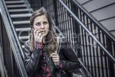 Young Bruised and Frightened Girl With Backpack on Staircase