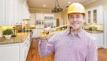 Contractor with Level Wearing Hard Hat Standing In Custom Kitche