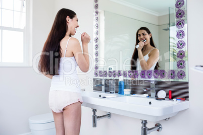 Brunette brushing teeth