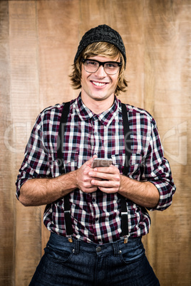 Smiling blond hipster holding smartphone
