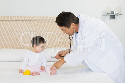 Cute baby being visited by doctor