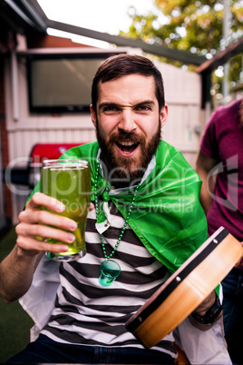 Disguised man holding a green pint