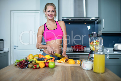 Fit woman cutting fruits