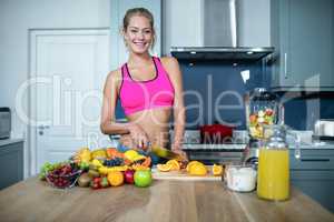 Fit woman cutting fruits