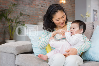 Mother giving milk in bottle to her daughter