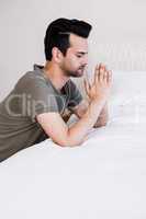 Handsome man praying before sleeping