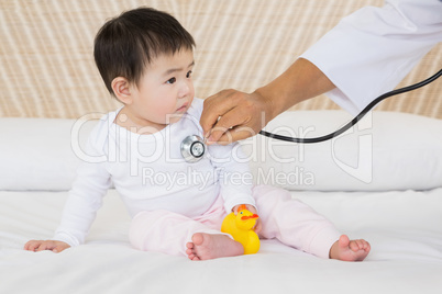 Cute baby being visited by doctor